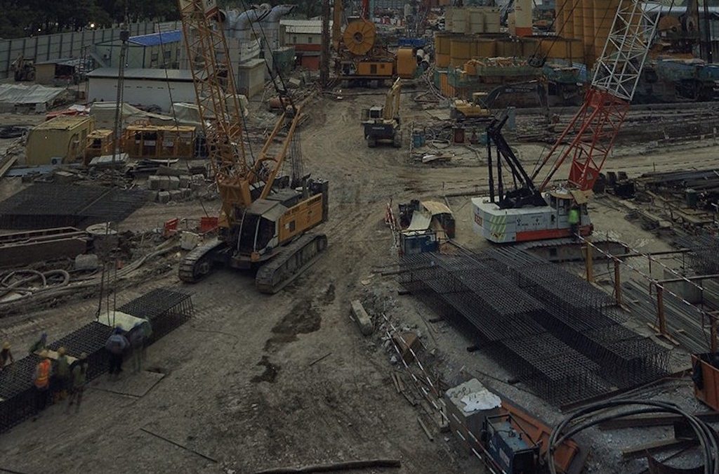 foto dari atas beberapa kendaraan alat berat sedang berada di area pertambangan