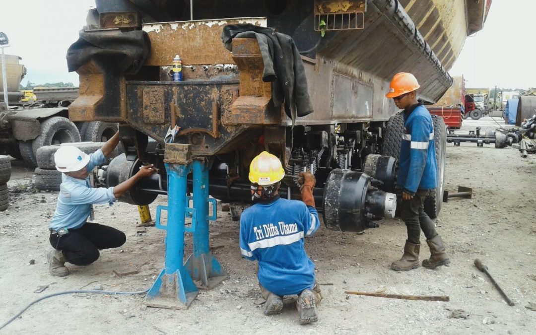 pekerja TDU sedang melakukan perawatan pada truk/trailer tambang