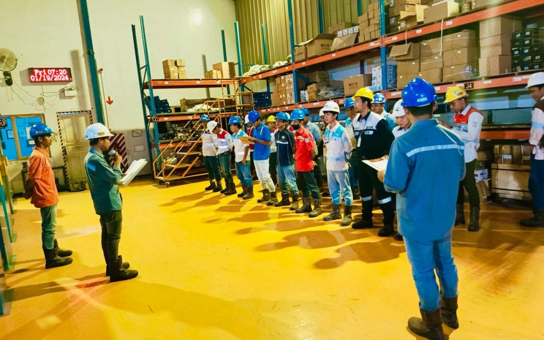 pekerja sedang berkumpul mendengarkan SOP keselamatan sebelum memulai kerja