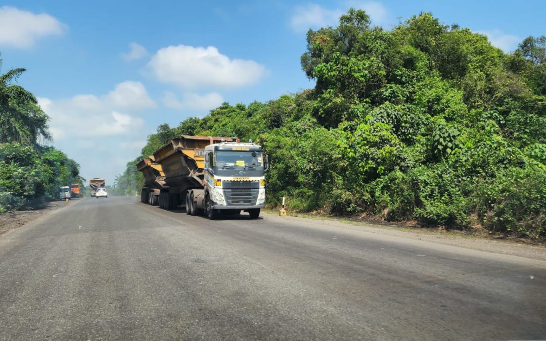 trailer sedang berjalan diantara pepohonan