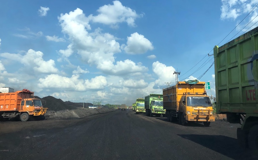 suasana truck sedang melintas di jalanan sekitar pertambangan