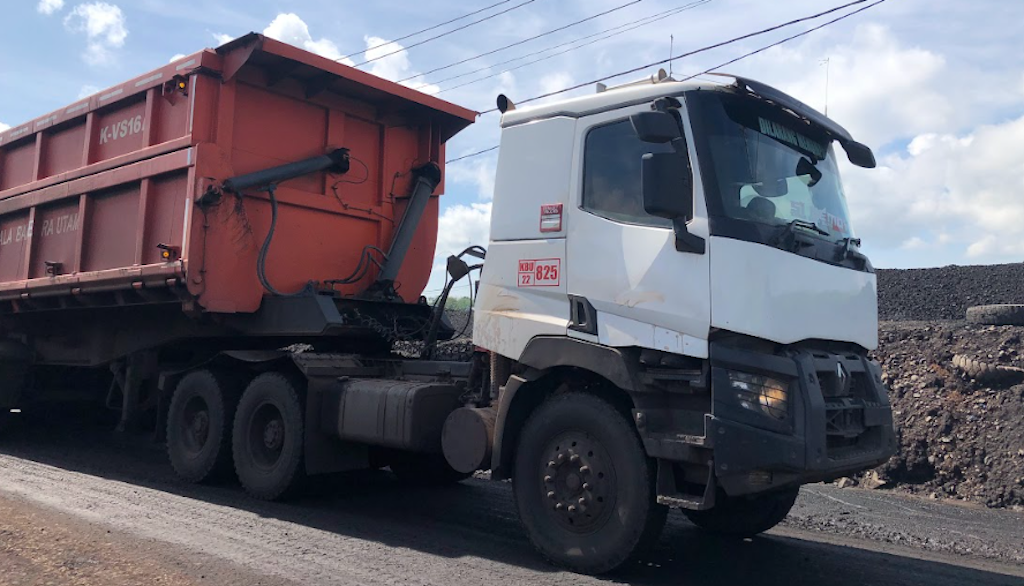 kendaraan alat besar berwarna merah dan putih didaerah pertambangan