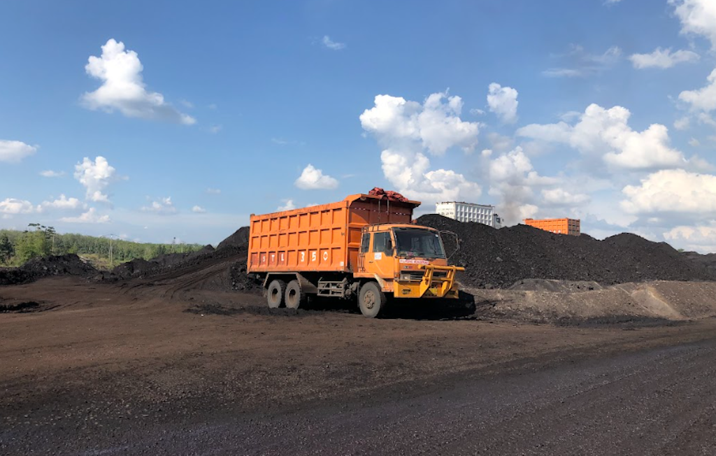 truck berwarna orange sedang loading pasir