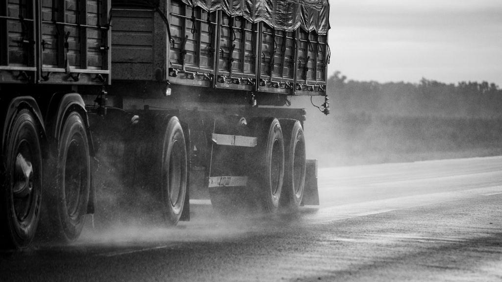 Monochrome view of a truck on wet road